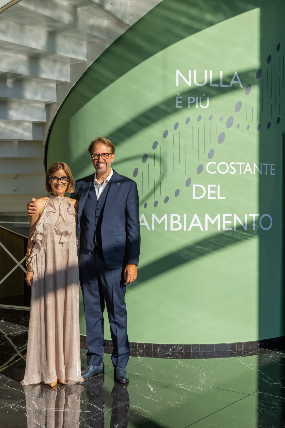 Due persone del team davanti alla parete verde dell'atrio