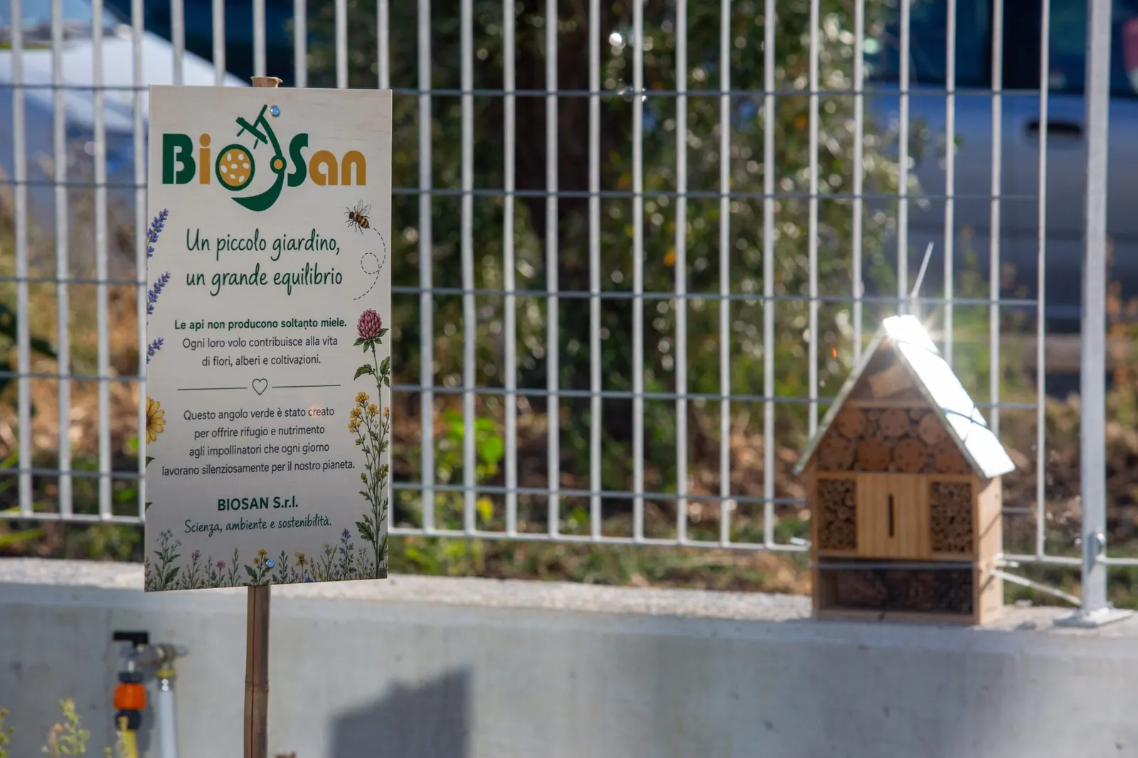 Il cartello del giardino per gli impollinatori accanto a una casetta per insetti